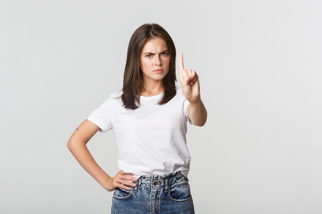 Femme déçue en colère, secouant le doigt en signe de désapprobation, grondant la personne prenant une mauvaise décision.