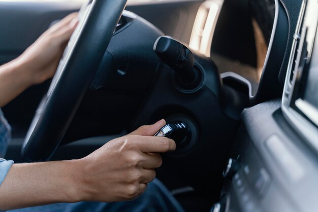 Femme démarrant le moteur de sa voiture