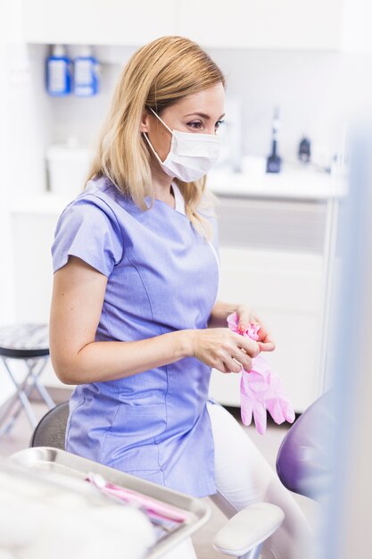 Femme dentiste avec des gants en clinique