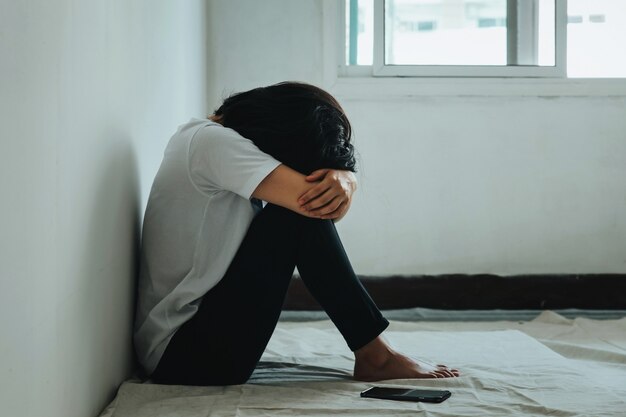 La Femme Depressive Etreint Son Genou Et Pleure Femme Triste Assise Seule Dans Une Piece Vide Photo Premium