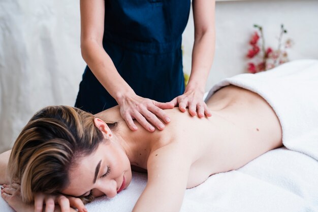 Femme détendue bénéficiant d'un massage du dos