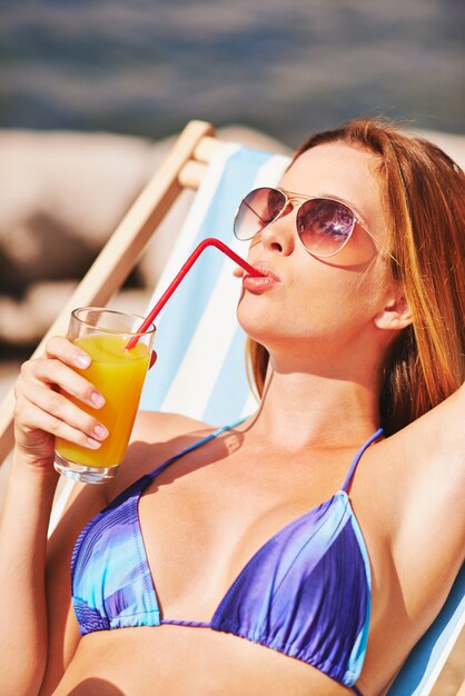 femme détendue boire un jus sur la plage