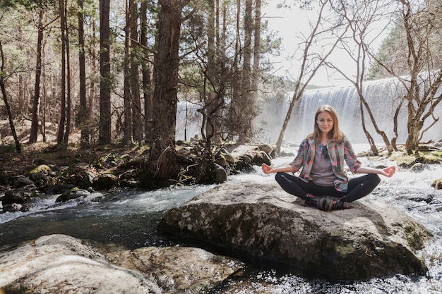 Femme détendue pratiquant le yoga à l&#39;extérieur