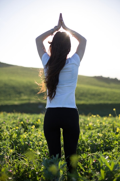 Photo gratuite femme de détente avec les mains sur le terrain vert