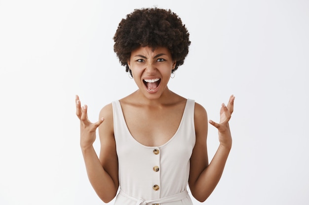 Femme en détresse et en colère étant sous pression, criant et serrant les mains de colère, grimaçant et fronçant les sourcils ayant une dispute