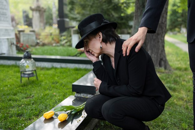 Femme en deuil au cimetière consolé par l'homme