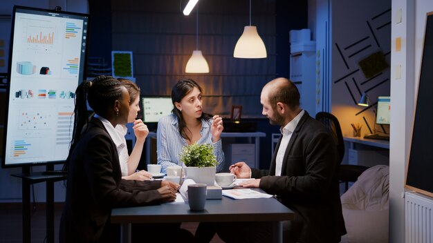 Femme directrice exécutive expliquant les statistiques de gestion travaillant à la stratégie de l'entreprise des heures supplémentaires dans la salle de réunion du bureau