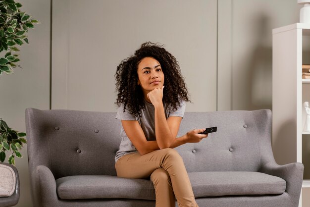 Femme, sur, divan, regarder télé