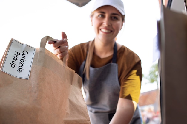 Photo gratuite femme donnant une commande à un ramassage en bordure de rue à l'extérieur