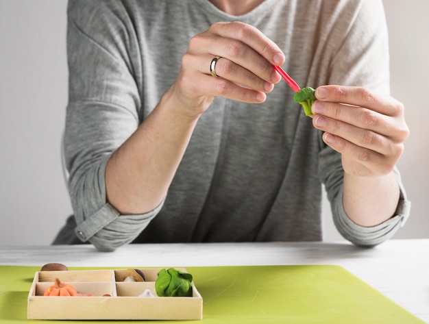 Photo gratuite femme donnant la forme de l'argile pendant la fabrication du brocoli à partir d'argile