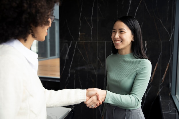 Femme donnant une poignée de main à son collègue au travail