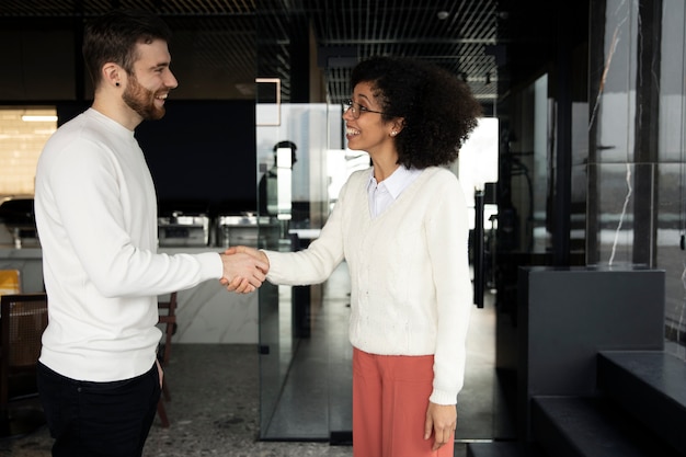 Femme donnant une poignée de main à son collègue au travail