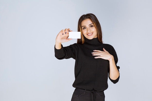 femme donnant ou recevant une carte de visite et a l'air surprise.