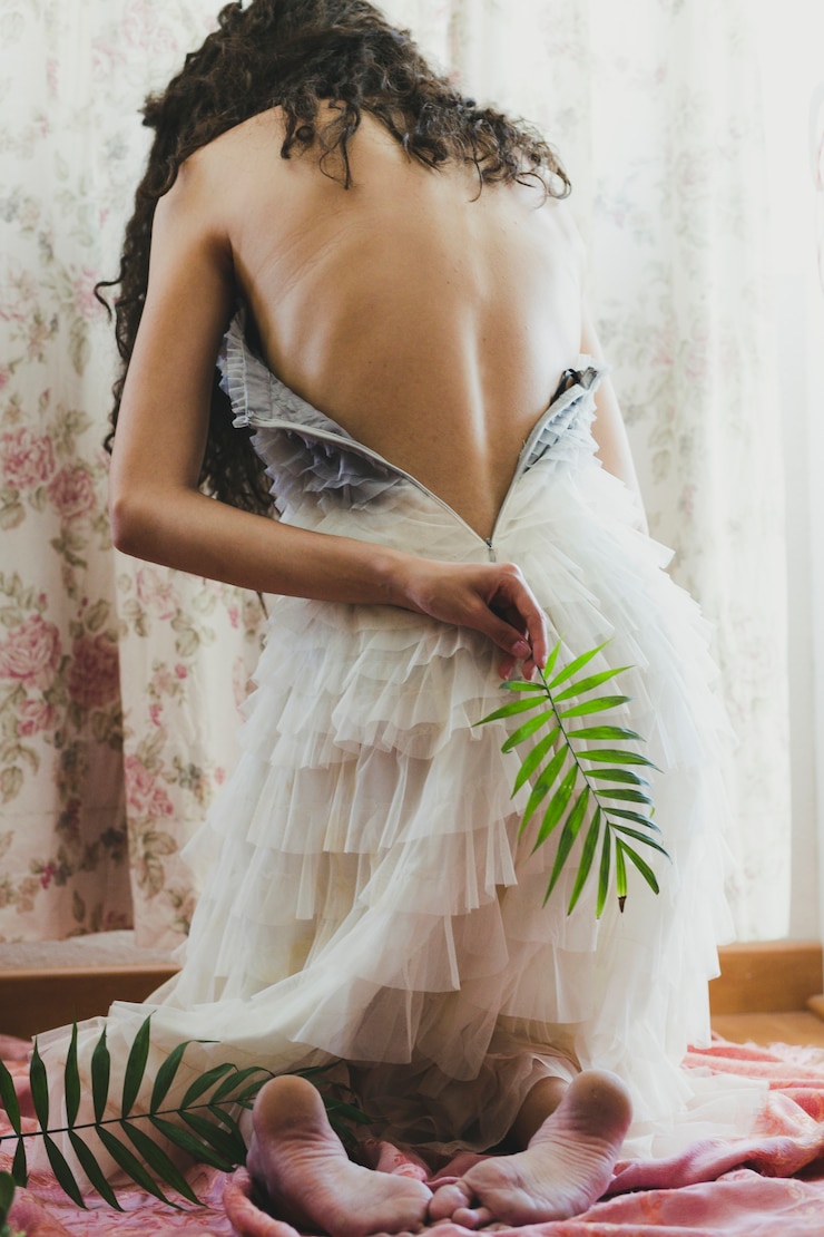 Photo gratuit femme avec dos nu tenant des feuilles