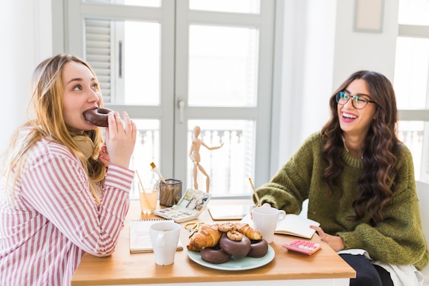 Femme drôle, manger des beignets et dessiner