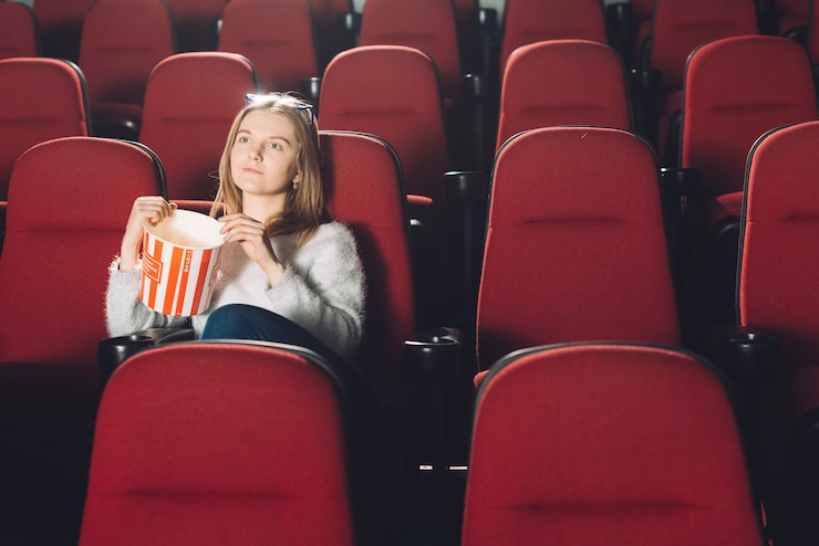 Photo gratuit femme avec du pop-corn dans l'auditorium du cinéma