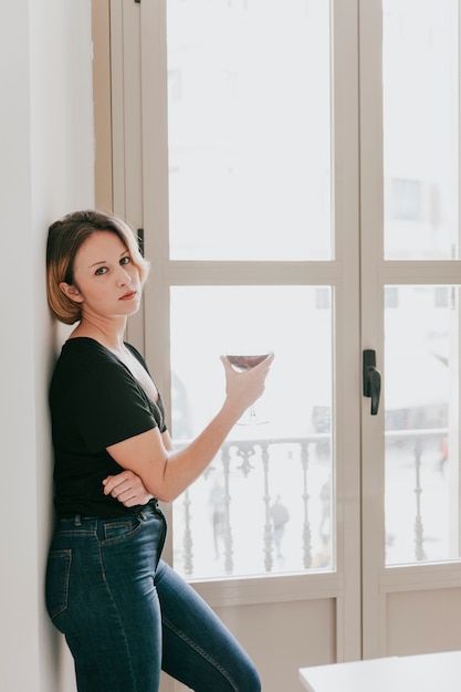 Femme avec du vin à la fenêtre