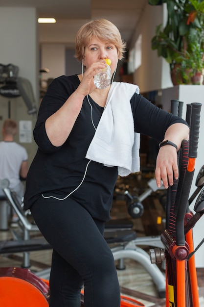 Femme écoutant de la musique et de l'eau potable