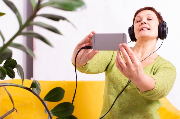 Femme écoutant de la musique et prenant un selfie