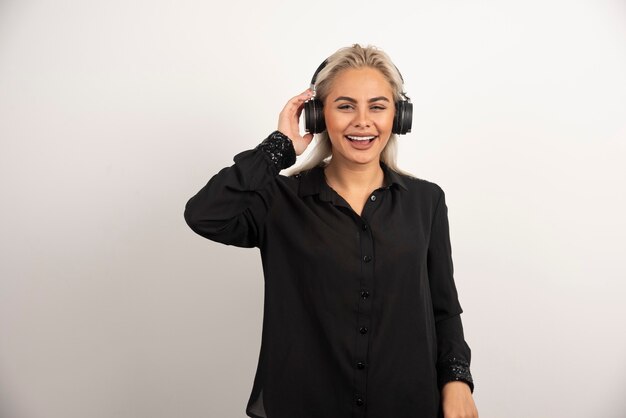 Femme écoute chanson avec un casque sur fond blanc. Photo de haute qualité