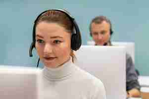 Photo gratuite femme avec des écouteurs travaillant dans un bureau de centre d'appels