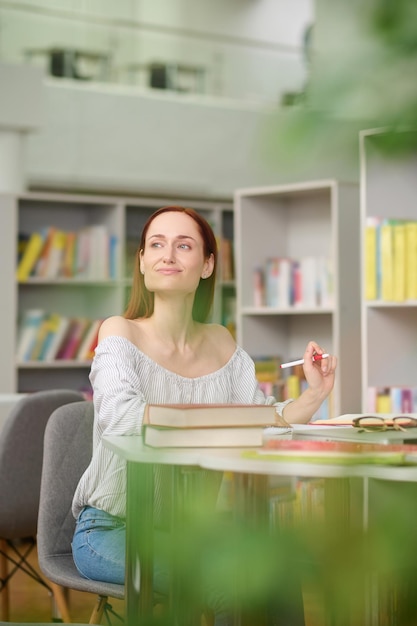 Femme écrit à table à côté pensivement