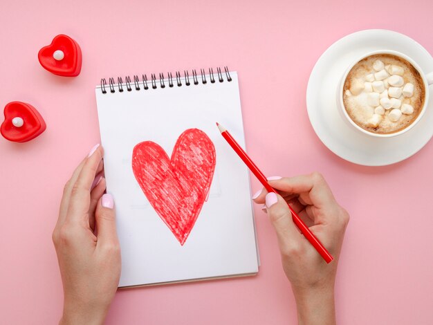 Femme écrivant sur le bloc-notes avec du café