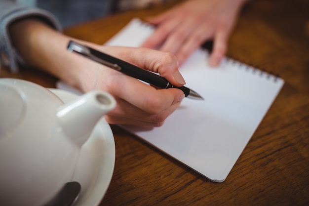 Femme écrivant sur le bloc-notes