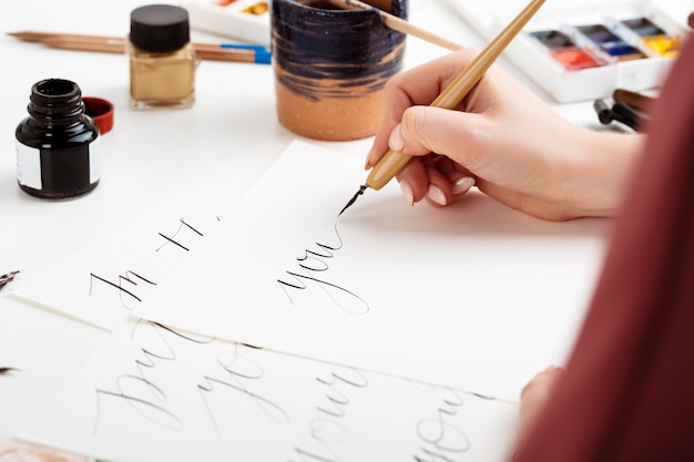 Photo gratuite femme écrivant la calligraphie sur des cartes postales