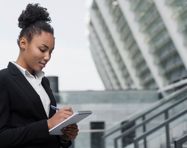 Femme écrivant dans le bloc-notes