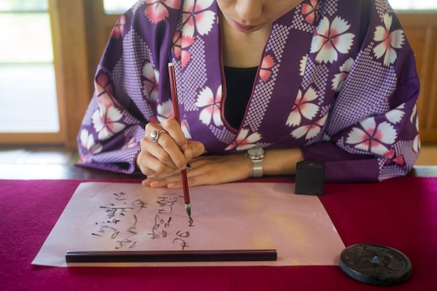 Femme écrivant à l'encre sur papier japonais