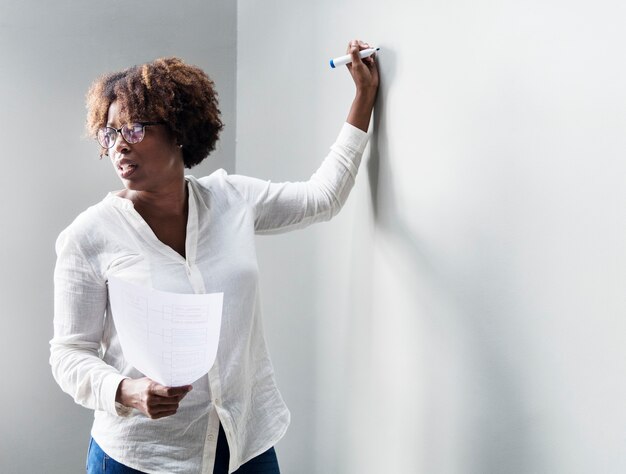 Femme écrivant sur un mur blanc