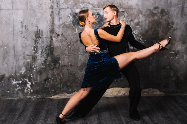 Femme effectuant split pendant la danse partenaire passionné