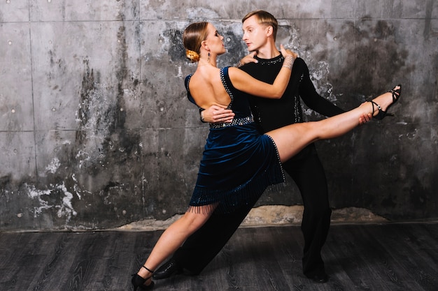 Femme effectuant split pendant la danse partenaire passionné