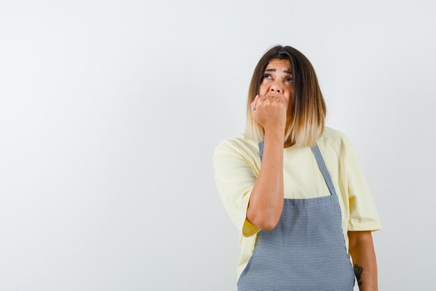 La femme effrayée met son poing sur la bouche sur fond blanc