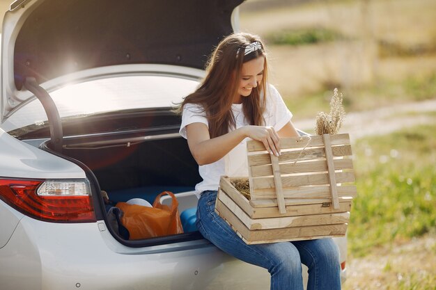 Femme élégante assise dans un coffre avec boîte en bois