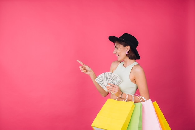 Femme élégante au chapeau sur un mur rouge rose