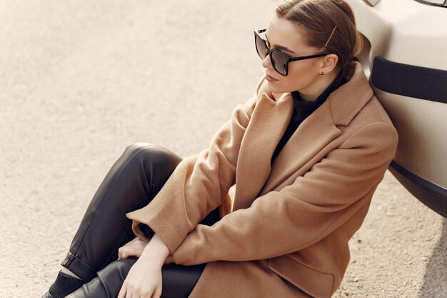 Femme élégante dans un manteau marron dans une ville de printemps