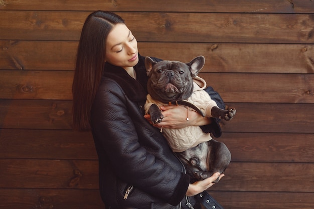 Femme élégante dans une veste noire avec bouledogue noir