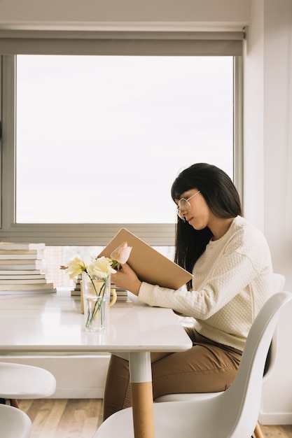 Femme élégante lecture à table