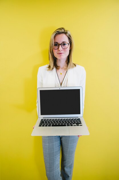 Femme élégante montrant un ordinateur portable moderne