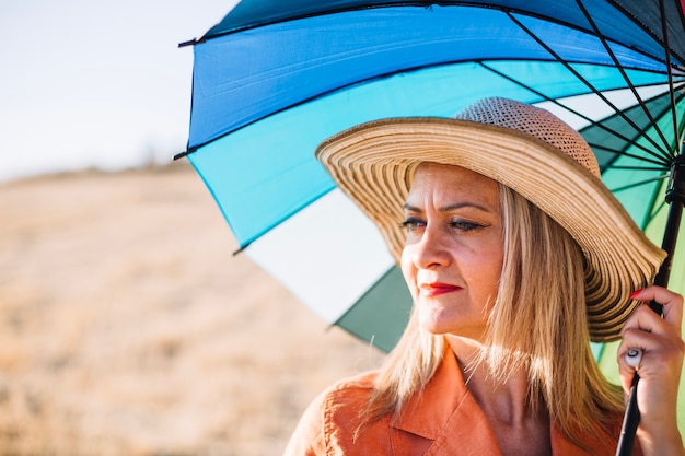 Femme élégante avec parapluie sur la nature