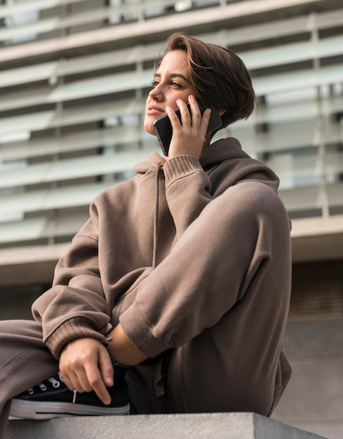 Femme élégante portant des vêtements de sport et parler au téléphone