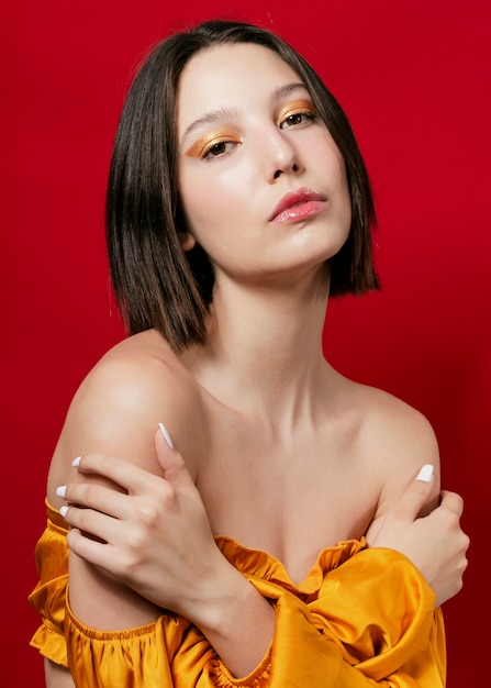 Femme élégante qui pose en robe jaune et les épaules nues