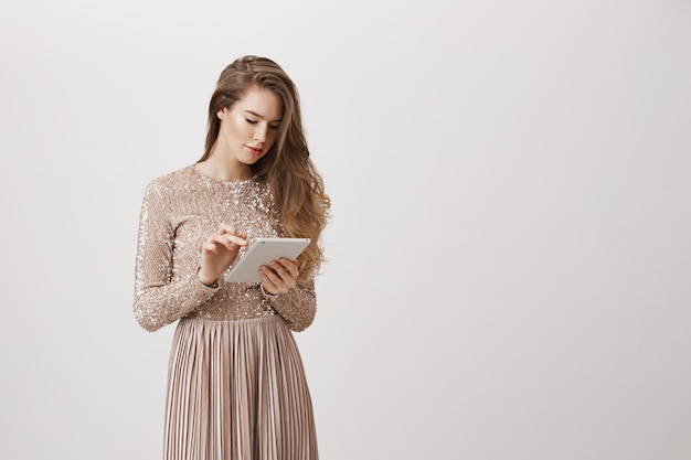 Femme élégante En Robe De Soirée à L'aide De Tablette Numérique