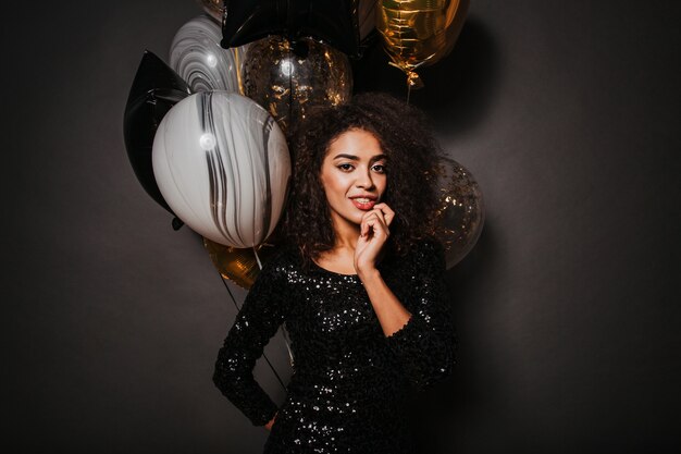 Femme élégante sensuelle tenant un bouquet de ballons de fête