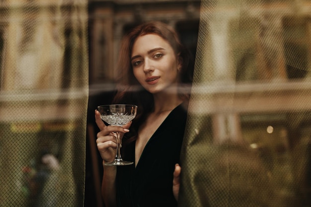 Une femme élégante tient un verre à martini
