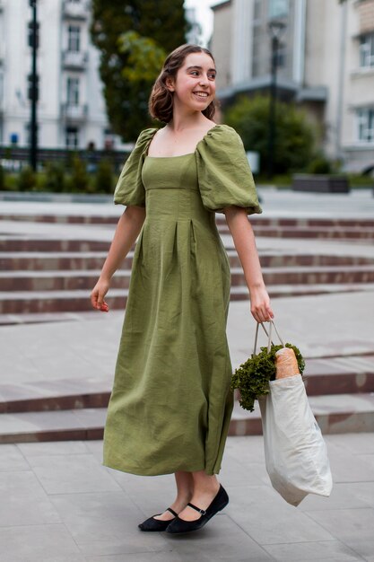 Femme élégante transportant des produits d'épicerie bio