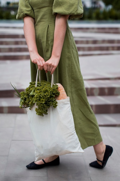 Photo gratuite femme élégante transportant un sac d'épicerie