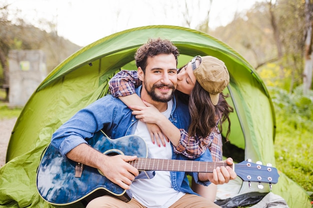 Femme embrassant et embrassant l&#39;homme avec la guitare